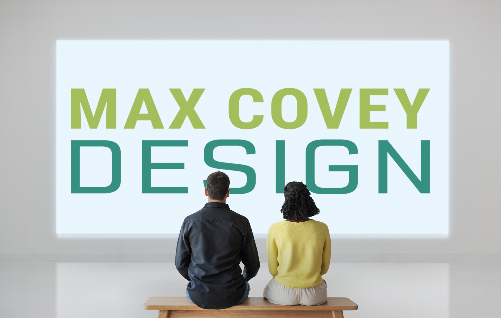 A couple looking at the Max Covey Design logo on a gallery wall